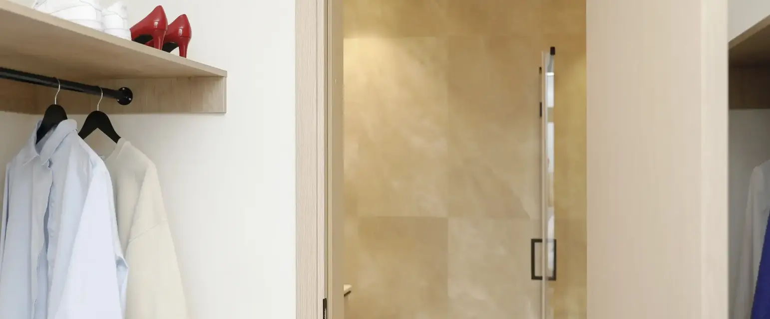 a bathroom with a white coat and red shoes