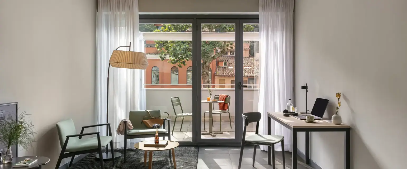 a room with a bed and a desk and chairs