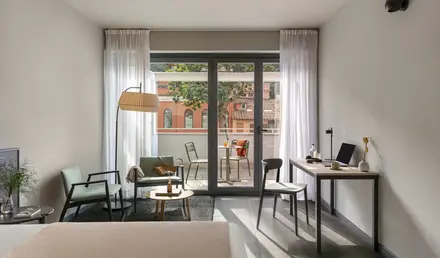 a room with a bed and a desk and chairs