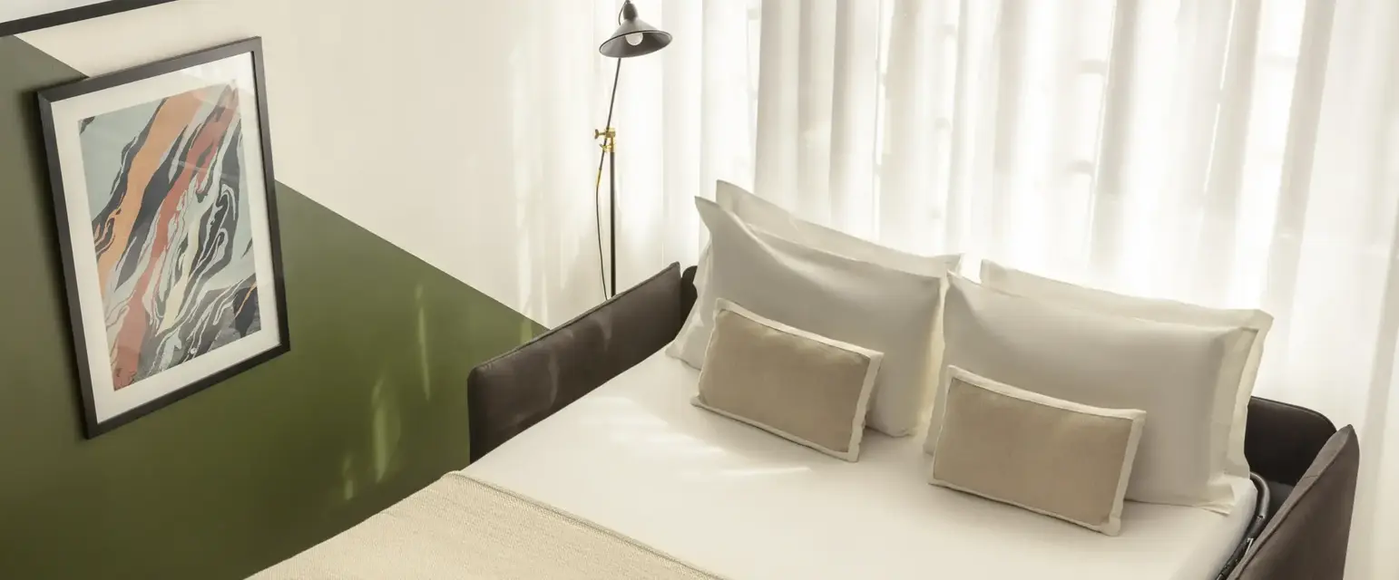 a bed with pillows and a lamp in a room