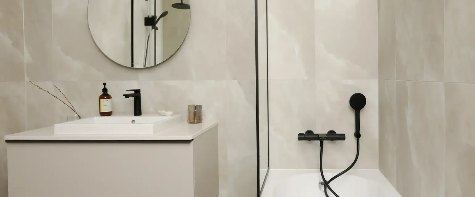 a bathroom with a round mirror and a bathtub