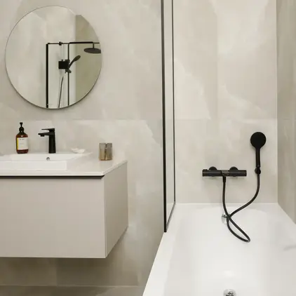 a bathroom with a round mirror and a bathtub