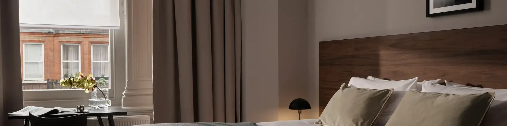 a bed with a black blanket and a chair in a room