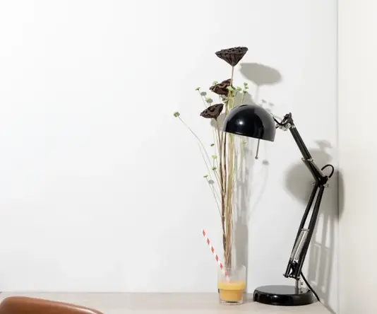 a plant in a glass with a straw on a table