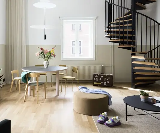 a room with a spiral staircase and a round table