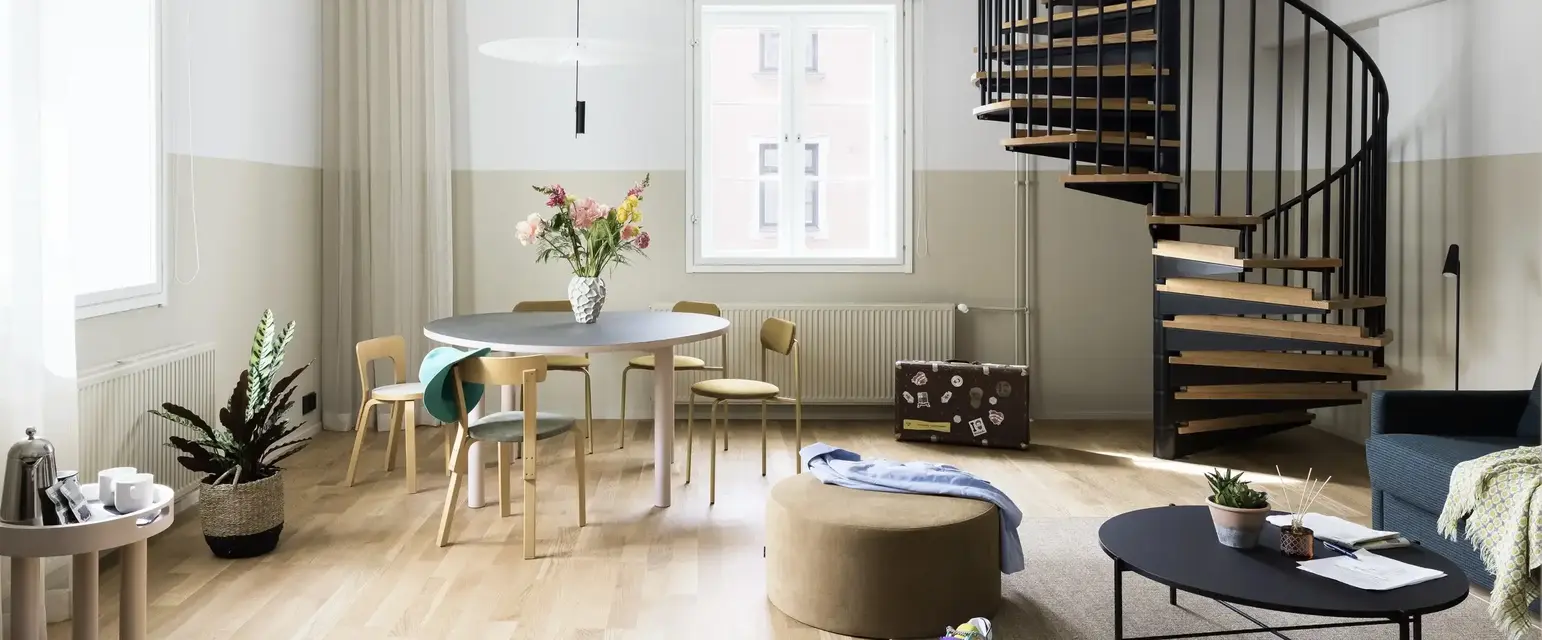a room with a spiral staircase and a round table