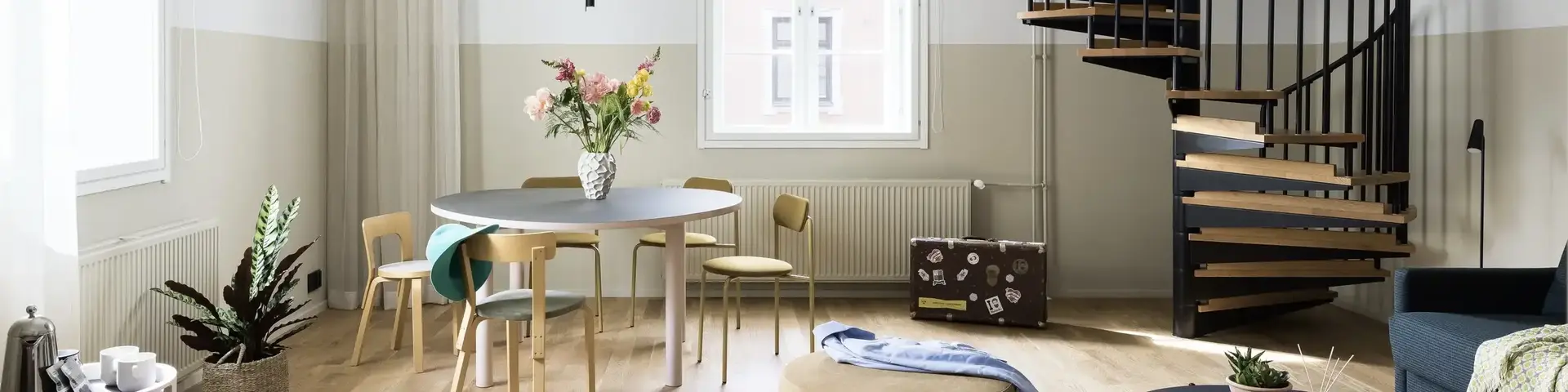 a room with a spiral staircase and a round table