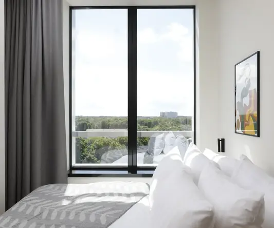 a bed with pillows and a picture on the wall