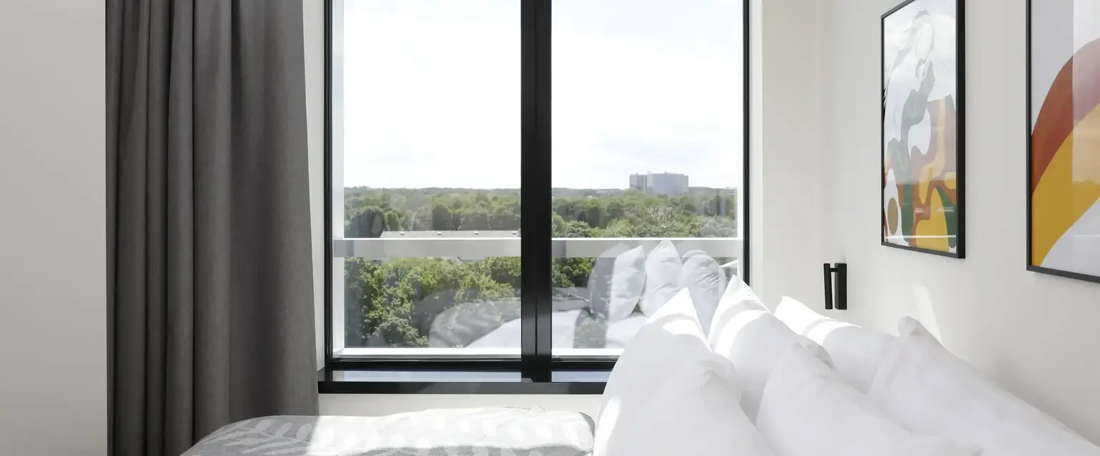 a bed with pillows and a picture on the wall