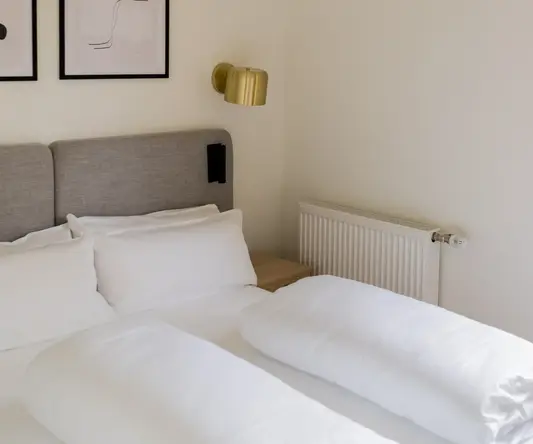 a bed with pillows and a lamp