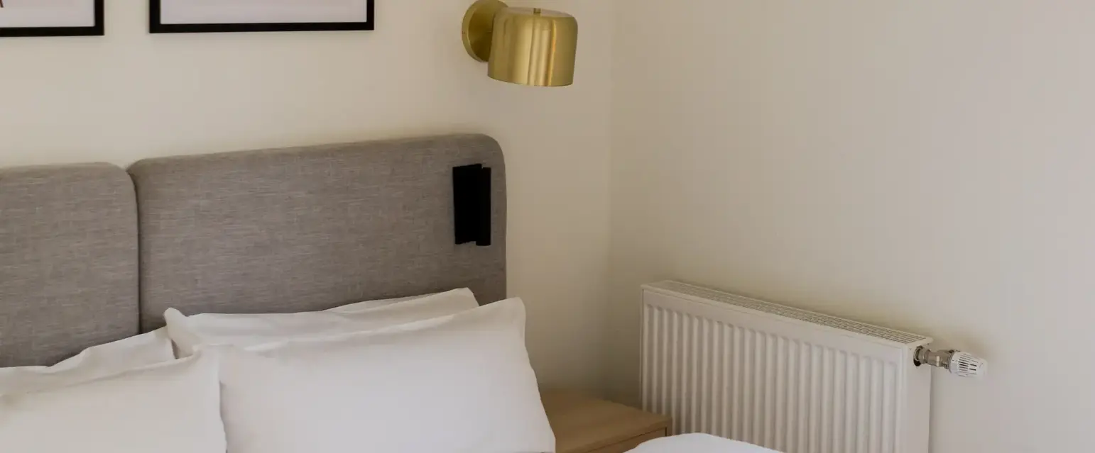 a bed with pillows and a lamp