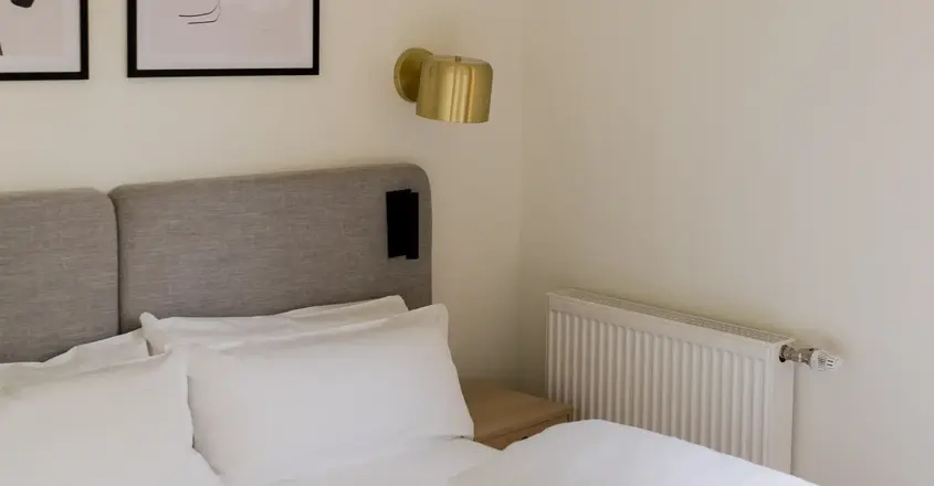 a bed with pillows and a lamp