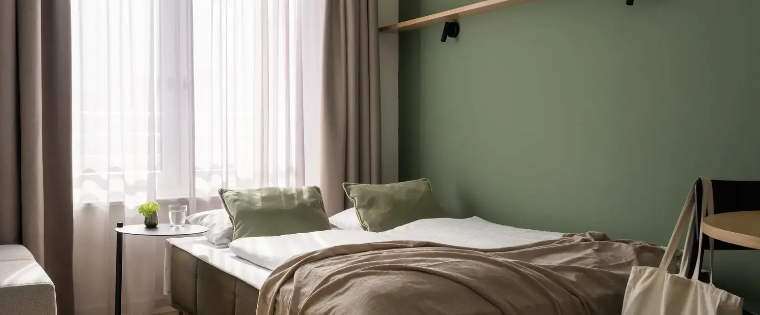 a bed with a green wall and a shelf