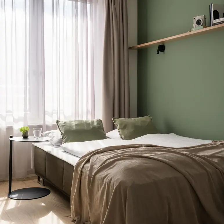 a bed with a green wall and a shelf