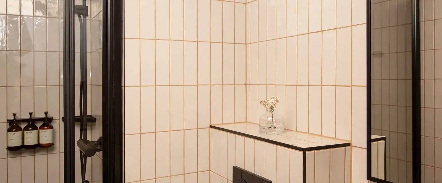 a shower with a small shelf