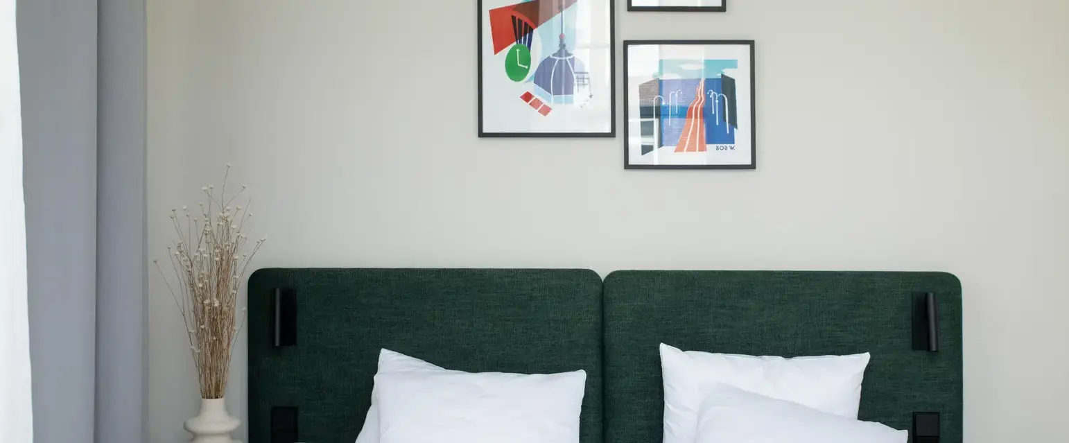 a bed with white sheets and pillows