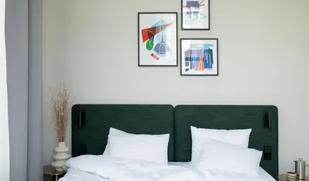 a bed with white sheets and pillows