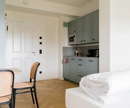 a room with a table and chairs and a bed