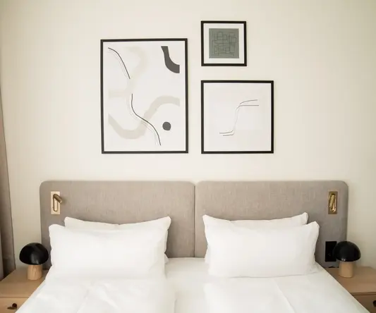 a bed with pillows and a picture on the wall