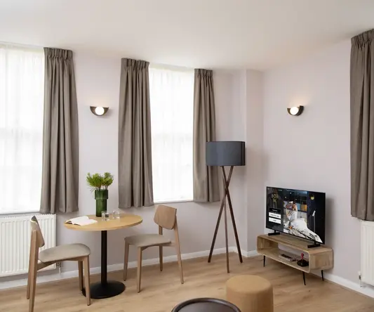 a room with a table and chairs and a television