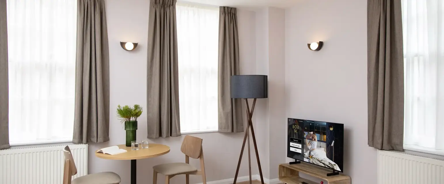 a room with a table and chairs and a television