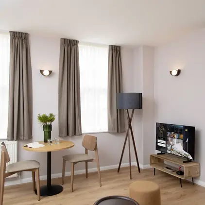 a room with a table and chairs and a television