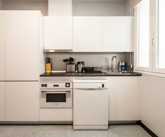 a kitchen with white cabinets and appliances