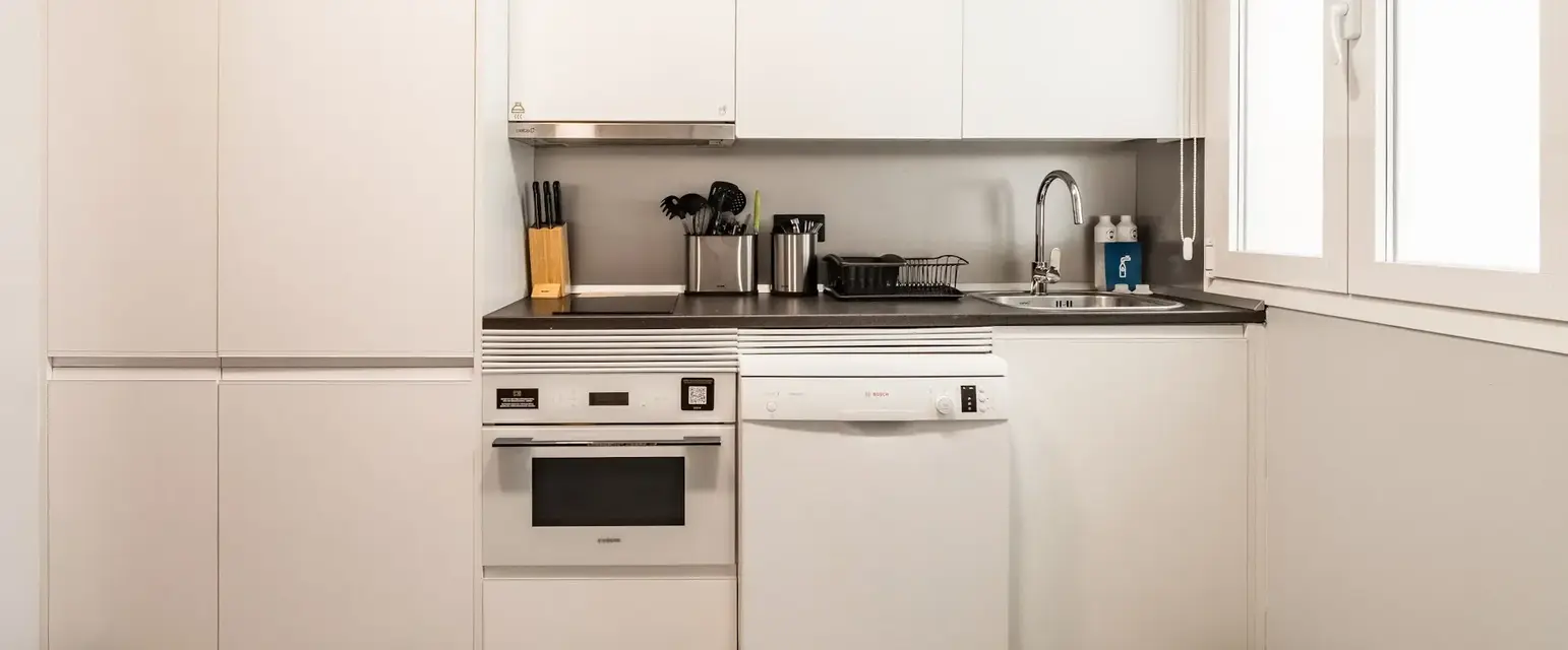 a kitchen with white cabinets and appliances