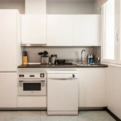 a kitchen with white cabinets and appliances