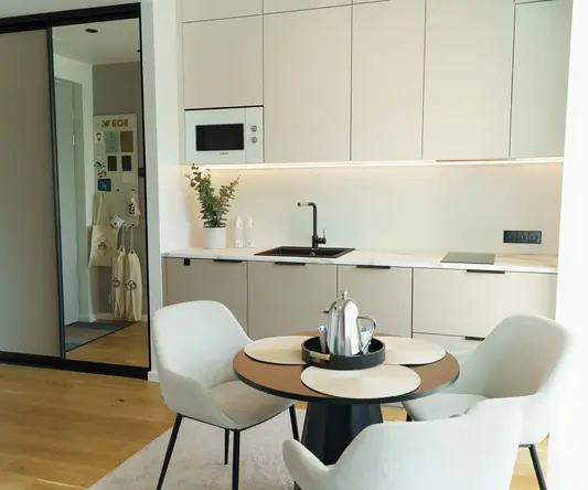 a kitchen with white cabinets and a table and chairs