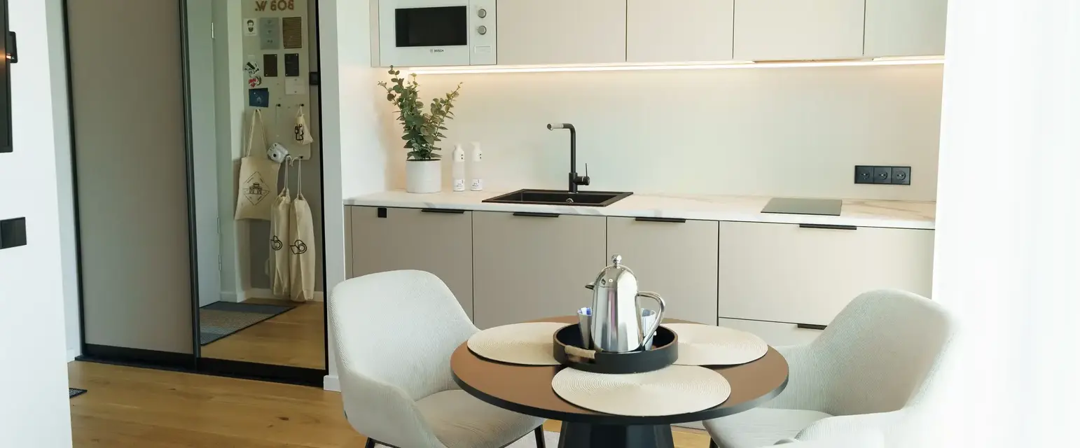 a kitchen with white cabinets and a table and chairs