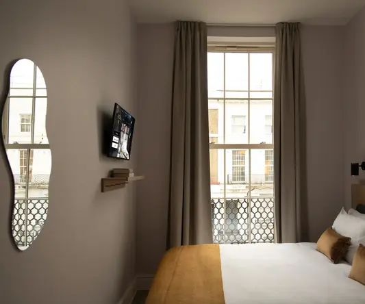 a bed in a room with a window and a television