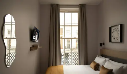 a bed in a room with a window and a television