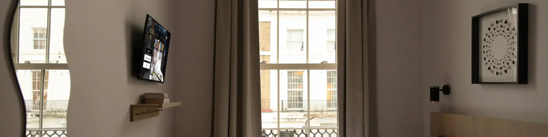 a bed in a room with a window and a television