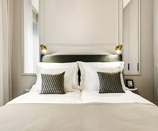 a bed with white sheets and pillows
