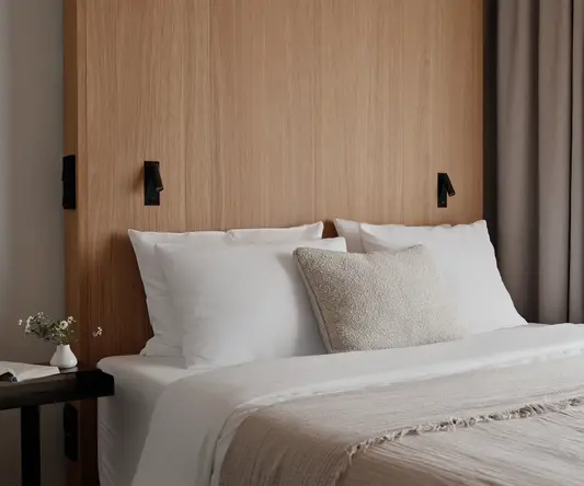 a bed with white pillows and a wood headboard