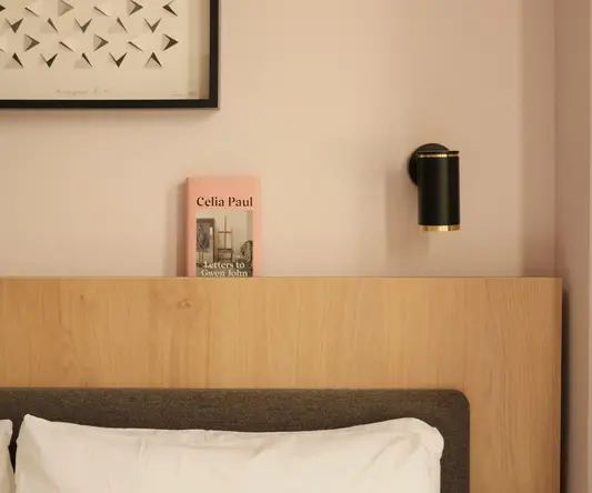 a bed with a wood headboard and a picture on the wall