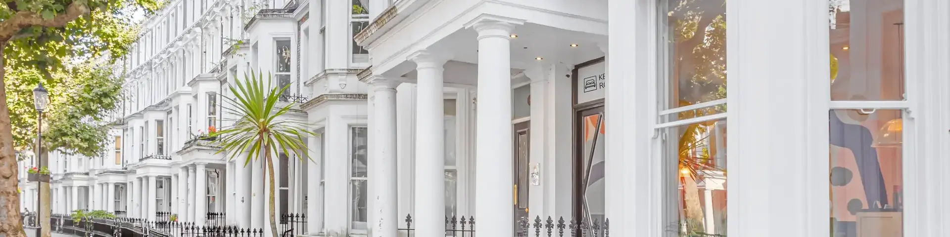 a white building with columns and a black fence