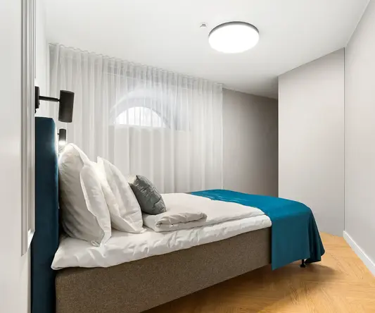 a bed with pillows and a lamp in a room