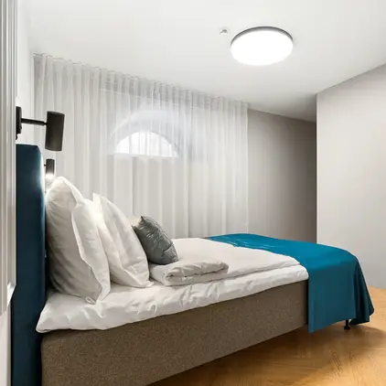 a bed with pillows and a lamp in a room