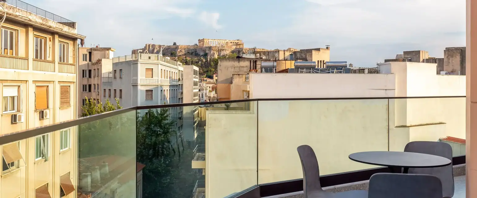 a balcony with chairs and a table and a glass railing