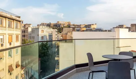 a balcony with chairs and a table and a glass railing