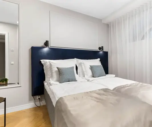 a bed with pillows and a blue headboard in a room