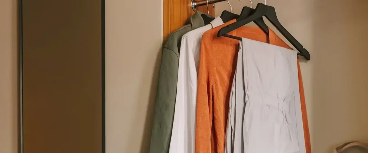 a closet with clothes and a mirror