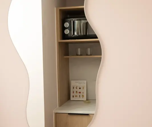 a mirror with a microwave and glasses on a shelf