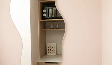 a mirror with a microwave and glasses on a shelf