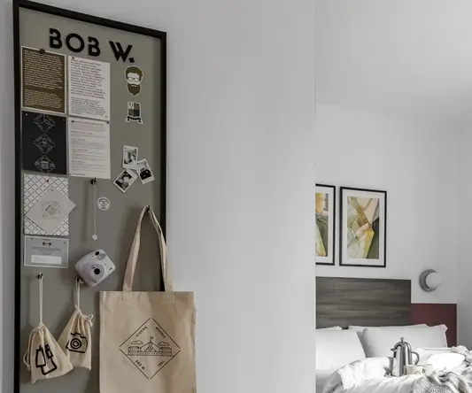 a room with a bed and a bulletin board