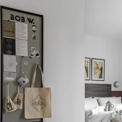 a room with a bed and a bulletin board