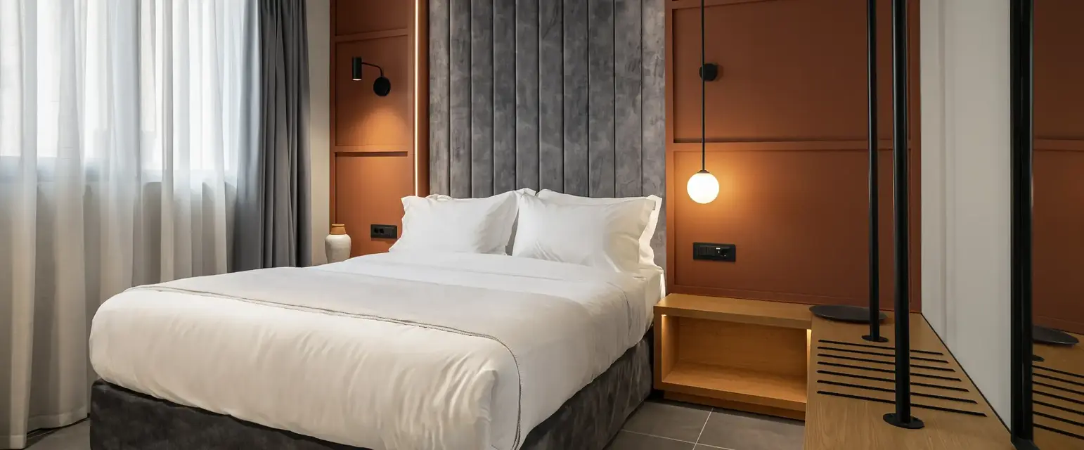 a bed with a lamp and a wall behind it