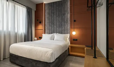 a bed with a lamp and a wall behind it